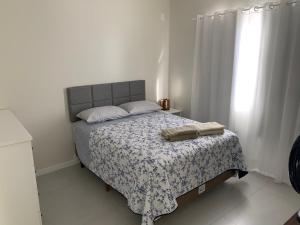 ein Schlafzimmer mit einem Bett mit einer Decke und einem Fenster in der Unterkunft Apartamento 3100 in Balneário Camboriú