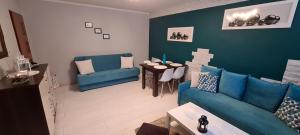 sala de estar con sofá azul y mesa en Quiet Basement Apartment, en Poznan