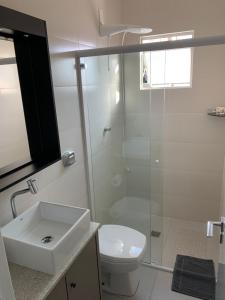 ein Bad mit einer Dusche, einem Waschbecken und einem WC in der Unterkunft Apartamento 3100 in Balneário Camboriú
