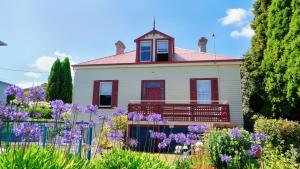 a house with purple flowers in front of it at Waterfront Lodge Motel in Hobart