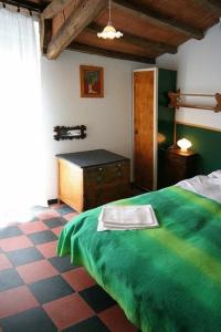 a bedroom with a green bed and a desk at Hotel Gianni Franzi in Vernazza