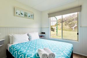 a bedroom with a bed and a large window at Kennett River Family Caravan Park in Wye River