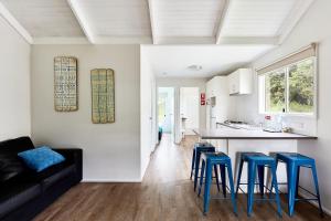 cocina y sala de estar con taburetes azules en Kennett River Family Caravan Park, en Wye River