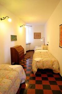 a bedroom with two beds and a checkered floor at Hotel Gianni Franzi in Vernazza
