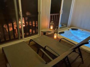 a hot tub on a balcony with a table and chairs at 1 and Only Riverside Accommodations in Sable River