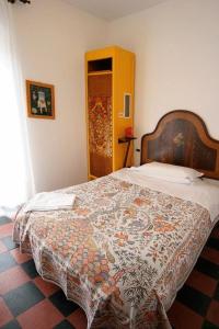 a bedroom with a bed with a flowered blanket on it at Hotel Gianni Franzi in Vernazza