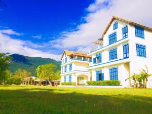 
a large white house with a blue sky at Vietnam Backpacker Hostels - Ninhvana in Nha Trang
