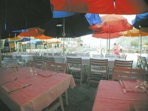 a restaurant with tables and chairs with umbrellas at Hotel Gianni Franzi in Vernazza