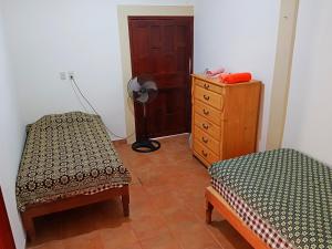 1 dormitorio con 2 camas, vestidor y puerta en Casa Cerca de La Media Luna en Río Verde