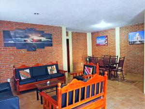 een woonkamer met meubels en een bakstenen muur bij Casa Cerca de La Media Luna in Río Verde