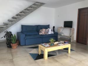 Una sala de estar con un sofá azul y una mesa de café. en Casa espaçosa cpm linda vista pro verde, en Búzios