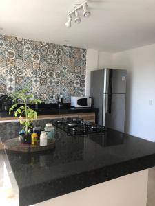 Una cocina con encimera negra y refrigerador. en Casa espaçosa cpm linda vista pro verde, en Búzios 6 fotos más
