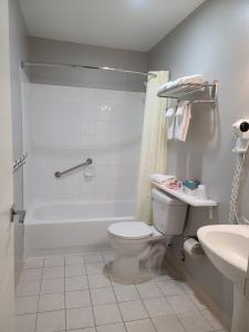 een badkamer met een bad, een toilet en een wastafel bij Tulip Inn Mount Vernon in Mount Vernon
