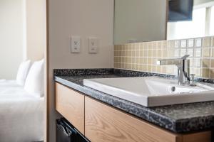 a bathroom with a sink and a bed at Hotel Vista Osaka Namba in Osaka