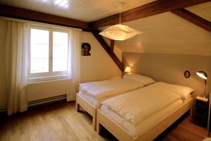 twee bedden in een kamer met een raam bij Gasthaus Schlosshalde in Winterthur