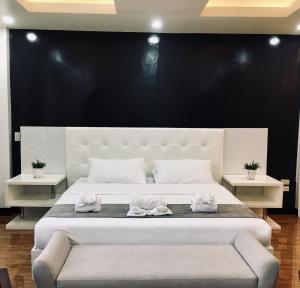 - un grand lit blanc avec 2 serviettes dans l'établissement Rangya Hotel, à Tagaytay