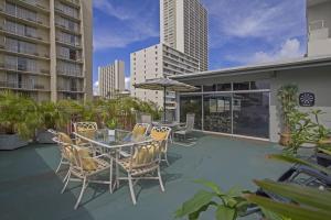 un patio con tavolo e sedie su un edificio di Royal Waikiki Penthouses a Honolulu