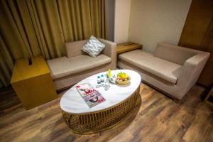 a living room with a coffee table and a couch at Citadel Hotel By Vinnca in Hyderabad