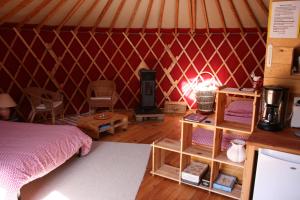 a room with a bed and a fireplace in a yurt at Yourtes en Terrasse in Bonneval