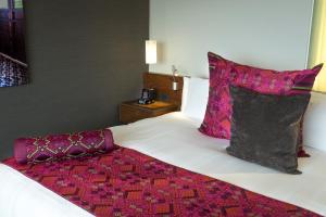 a bedroom with a bed with purple pillows at InterContinental Presidente Mexico City, an IHG Hotel in Mexico City