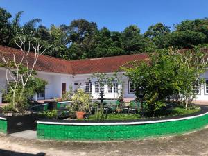 a house with a garden in front of it at Hotel Purnama Lenggang in Gantung
