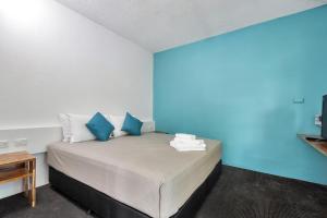 una camera da letto con un letto con pareti blu di Capitanos a Darwin