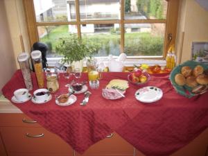 a table with a red table cloth with food on it at Kappes-Koppelkamm in Zeltingen-Rachtig