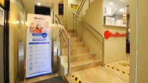 um conjunto de escadas numa loja com uma placa em RedDoorz at Hotel Rosemarie em Manila