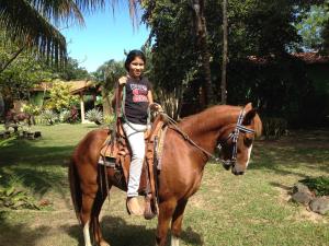 a young girl riding on a brown horse at Tranquility Bay Beach Retreat in Trujillo