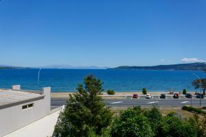 uma vista para um parque de estacionamento e para o oceano em Baycrest Thermal Lodge em Taupo