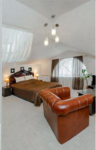 1 dormitorio con cama y sofá de cuero en Voskresenskaya Hotel, en Cherepovets