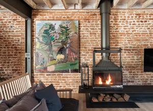 a living room with a brick wall with a fireplace at Mona Farm in Braidwood