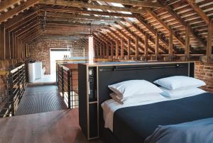 a bedroom with a large bed in a brick wall at Mona Farm in Braidwood