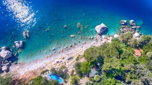 uma vista aérea de uma praia com rochas e do oceano em Nautical Hotel em Faralya