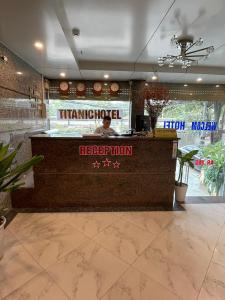 a man standing at a counter in a restaurant at TITANIC HOTEL in Hanoi