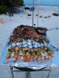 una bandeja de comida en una mesa en la playa en Adora en Malé