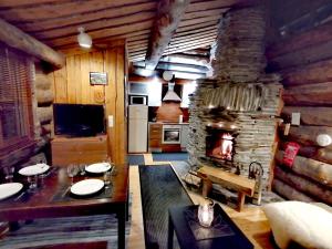 a living room with a stone fireplace in a cabin at Rantaruka Apartment in Ruka