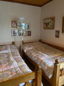 2 Betten in einem Schlafzimmer mit Bildern an der Wand in der Unterkunft Sandbergen - strandnära fritidshus in Mörbylånga