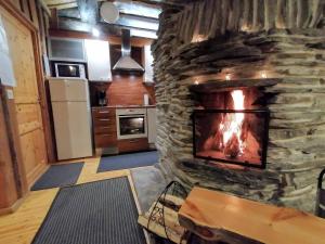 sala de estar con chimenea de piedra en la cocina en Rantaruka Apartment, en Ruka