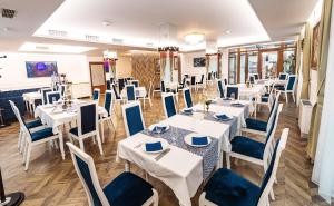 een eetkamer met witte tafels en blauwe stoelen bij Monte Vedetta in Sliven +57 foto's