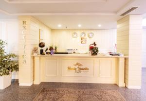 een restaurant lobby met een balie met een bord met magische tafels bij Monte Vedetta in Sliven