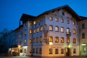 duży biały budynek z oświetleniem w obiekcie Hotel Gasthof Alte Post Holzkirchen w mieście Holzkirchen