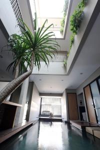 an indoor pool with a palm tree in a building at M Suite in Tangerang