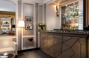a bar in a room with a couch and a chair at Elysées Union in Paris