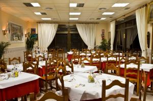 jadalnia z białymi stołami i drewnianymi krzesłami w obiekcie Hostal Rural Alba w mieście Los Albaricoques