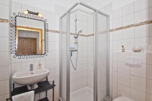 ein weißes Badezimmer mit Waschbecken und Dusche in der Unterkunft Ostseehaus Lea Doppelhaushälfte in Wiek auf Rügen 