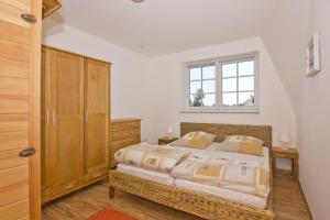 ein Schlafzimmer mit großem Bett und Fenster in der Unterkunft Ostseehaus Lea Doppelhaushälfte in Wiek auf Rügen 