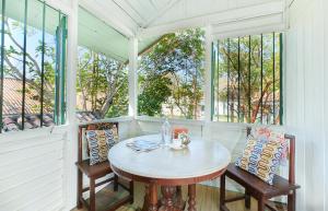 einen Tisch und Stühle auf einer Veranda mit Fenstern in der Unterkunft Temple Tree Resort in Pantai Cenang