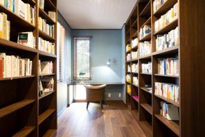 biblioteca con estanterías y silla en una habitación en Wataya - 市原 和多屋-, en Ichihara