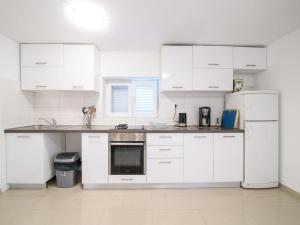a kitchen with white appliances and white cabinets at Elegant Holiday Home in Privlakaw with Garden in Privlaka